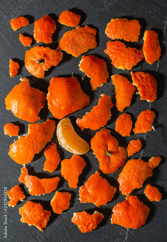 Mandarin and orange peels on a dark background.