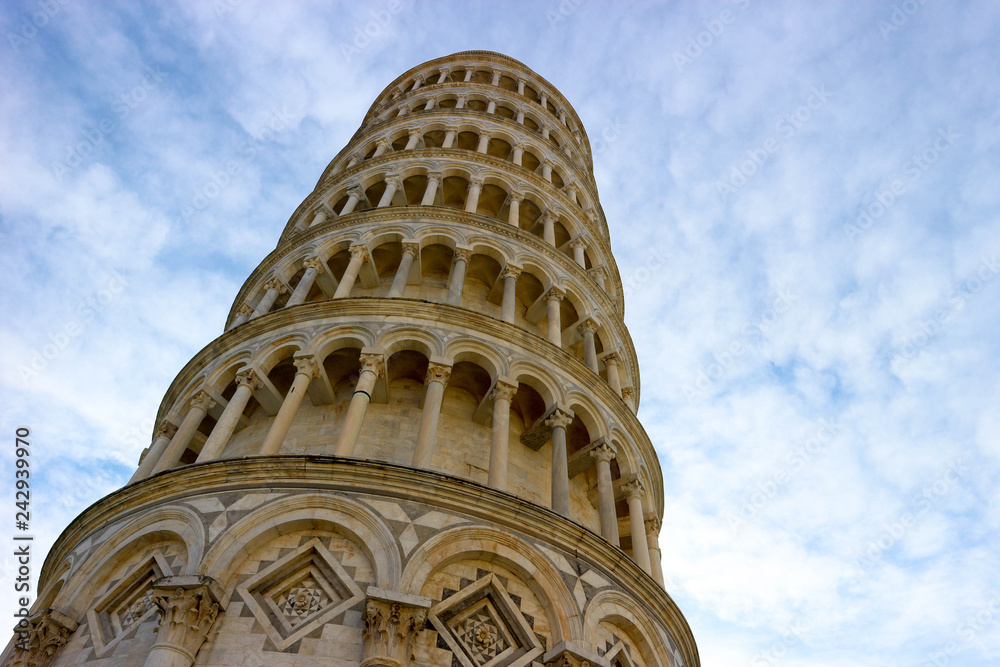 Closeup view to leaning tower of Pisa, symbol of Italy, with the clouds and blue sky on the background