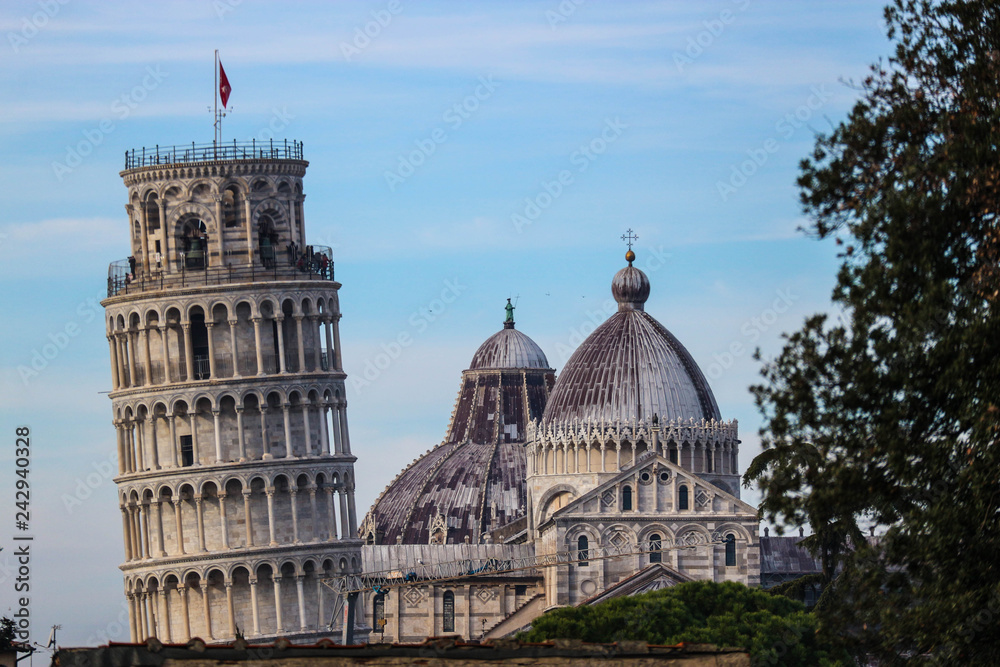 Tops of Pisa leaning tower with cathedral and baptistery, view from city wall, Tuscany, Italy