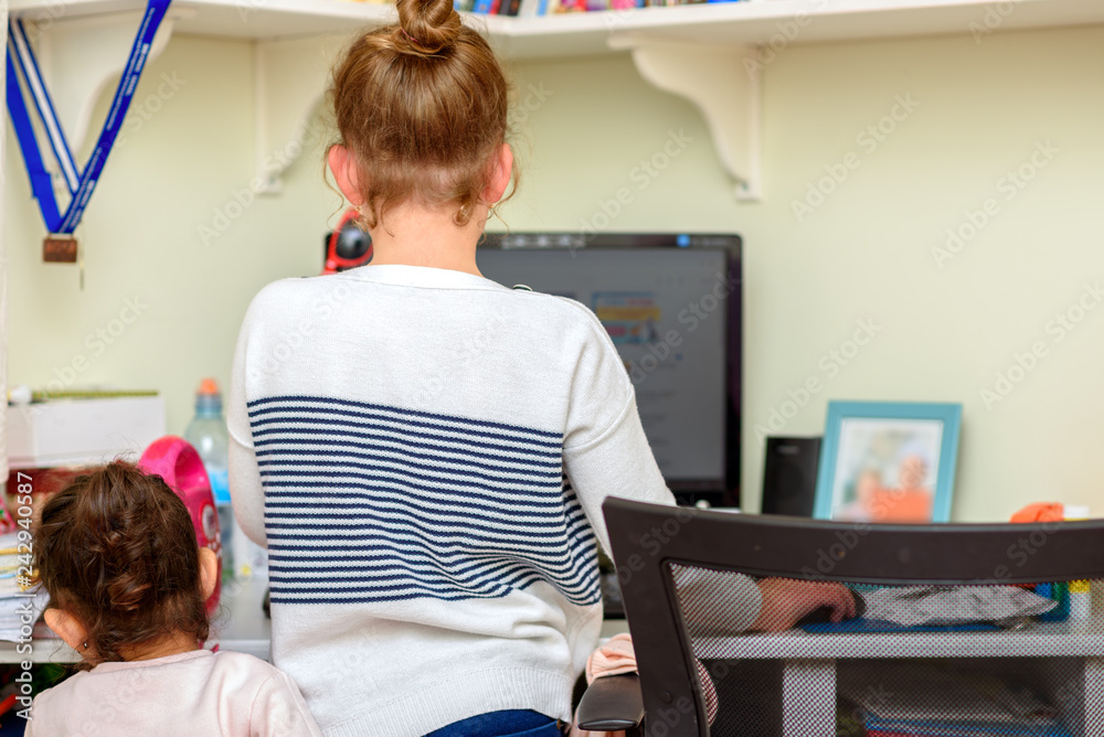 Young Little Blogger At Her Desk In Home Studio. Teenager Girl With Little Toddler Sister Webinar, Homework, E-learning Online In Home At Kid Room. Young Little Blogger At Her Desk In Home Studio. Teenager Girl With Little Toddler Sister Webinar, Homework, E-learning Online In Home At Kid Room.