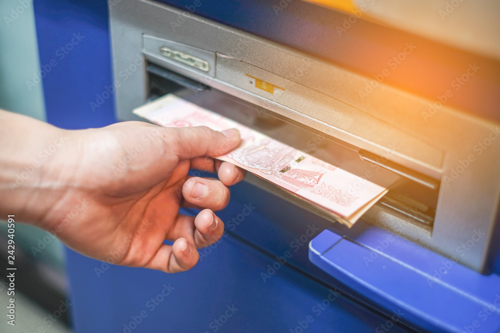 Woman hand withdrawing money from bank ATM machine.