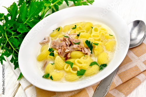 Soup creamy of chicken and pasta in plate on kitchen towel