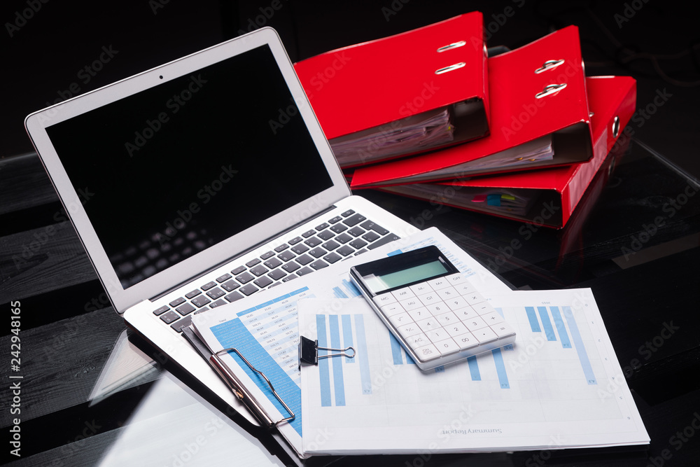 Office workplace with documents and stationery near red folders Office workplace with documents and stationery near red folders