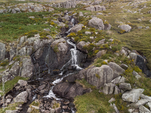 Aerial drone view landscape of river flowing down waterfall and over rocks in Snowdonia
