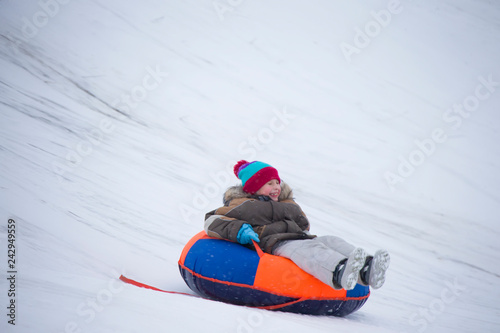 Sledding.Happy child on vacation. Winter fun and games.Little boy enjoying a sleigh ride.Children play outdoors in snow. Kids sled in the Alps mountains in winter