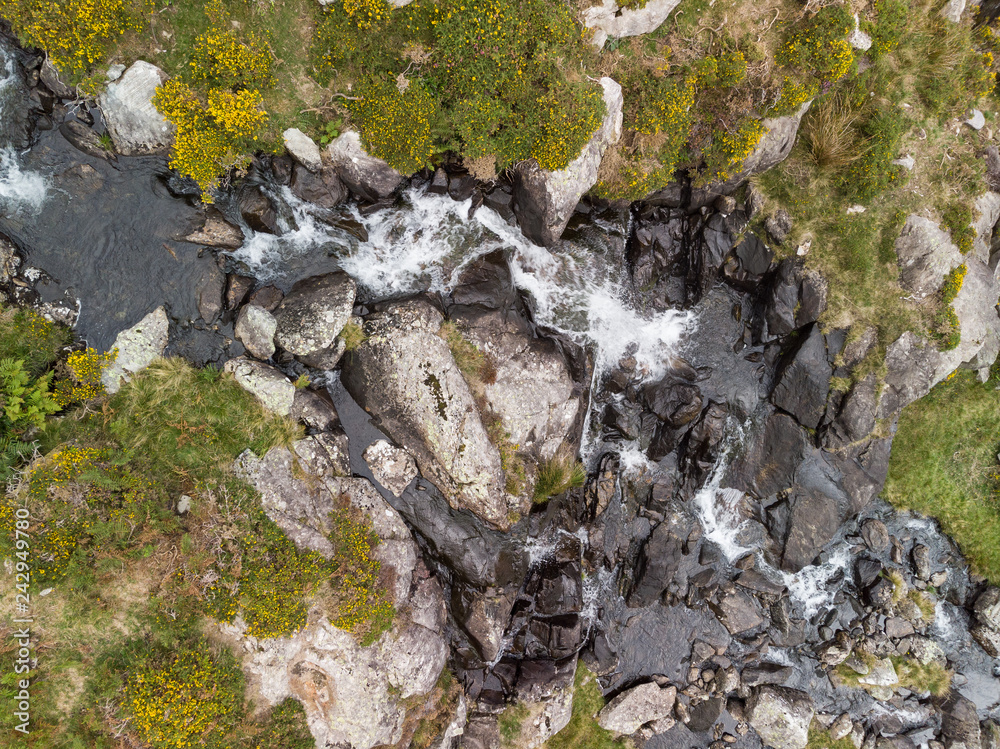 Obraz premium Aerial drone view landscape of river flowing down waterfall and over rocks in Snowdonia