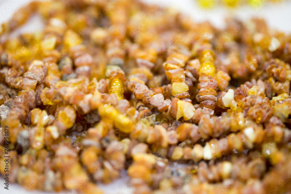 Fototapeta premium Raw amber stones, simple beads. Close-up. Amber background.