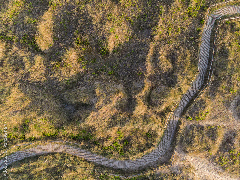 Drone bird's eye aerial view of grassy sand dunes on beach landscape at sunrise on English coast Drone bird's eye aerial view of grassy sand dunes on beach landscape at sunrise on English coast