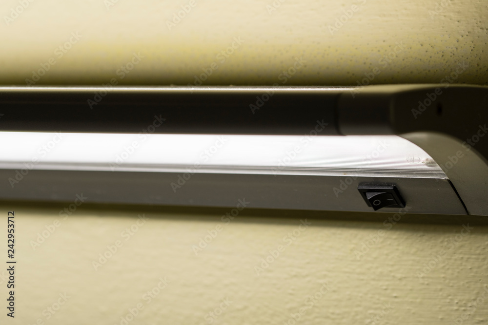 Black switch on wall fluorescent light. Black switch on wall fluorescent light.