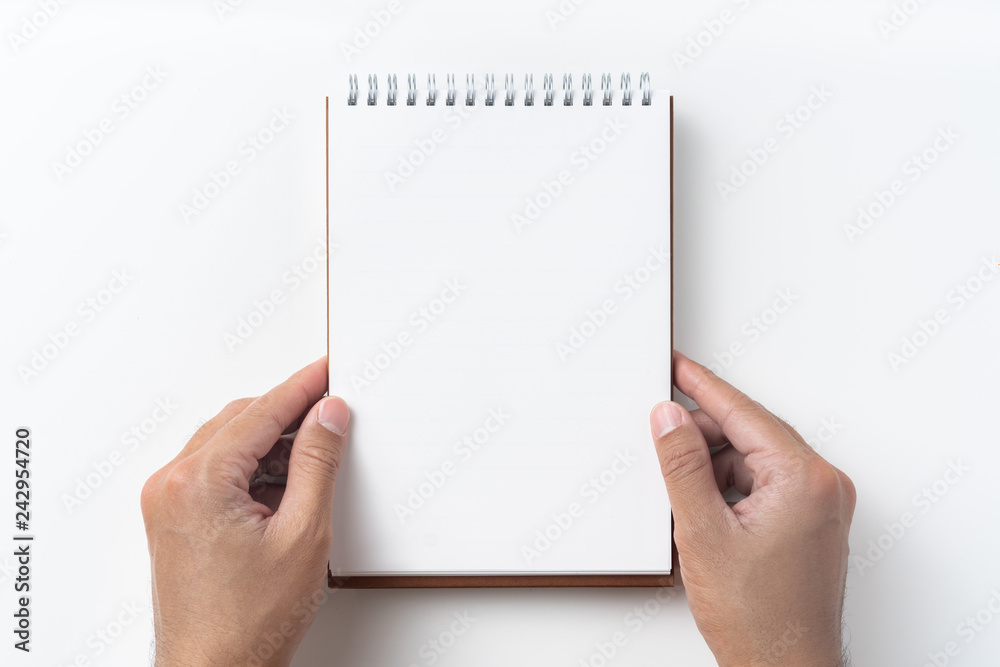 Top view of brown spiral notebook with hand Top view of brown spiral notebook with hand