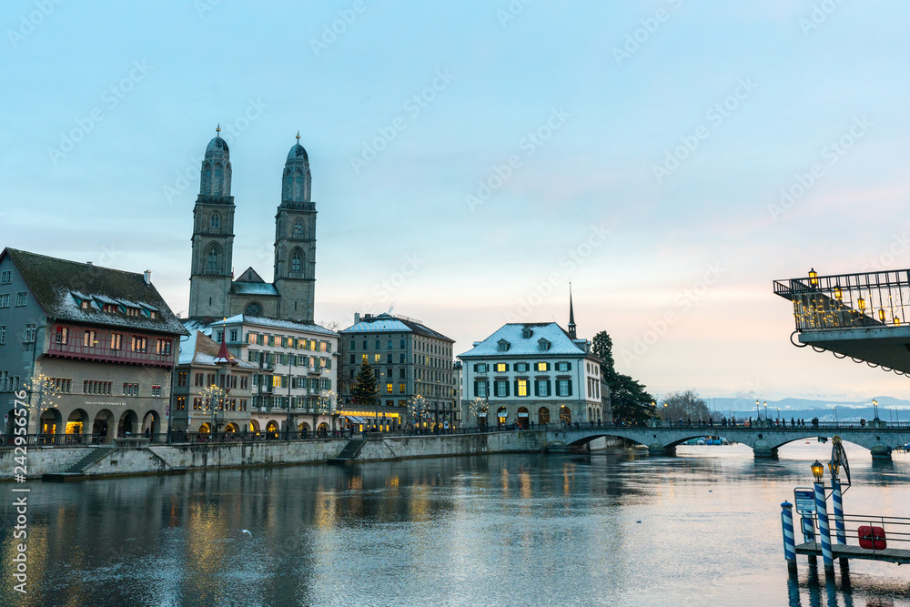 Zurich, ZH / Switzerland - January 4, 2019: many people crossing a bridge over the Limmat on their way to the Grossmuenster cathedral in Zurich