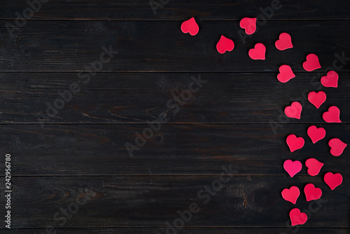 Wooden dark Background with Decorative red hearts for design to Valentine's Day. View from above. Valentines Day concept