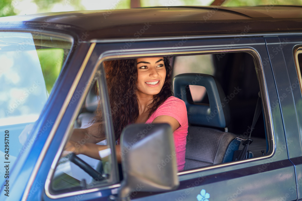 Young Arab woman driving an old van in nature