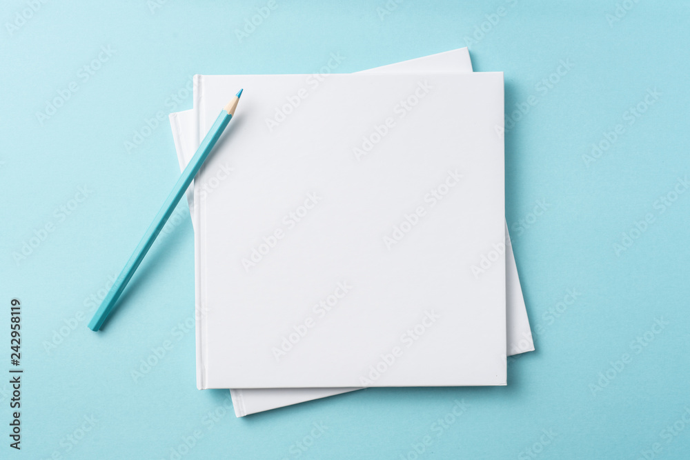Top view of white hardcover notebook on blue Top view of white hardcover notebook on blue