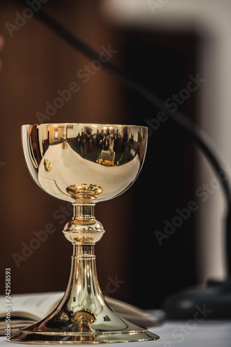 Holy communion on wooden table on church. Cup of glass with red wine, bread on wooden table. Holy Bible