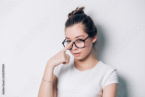Portrait of young beautiful brunette woman with glasses on white background