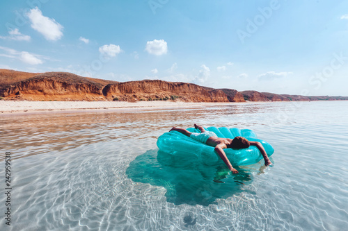 Man relaxing on inflatable ring on the beach