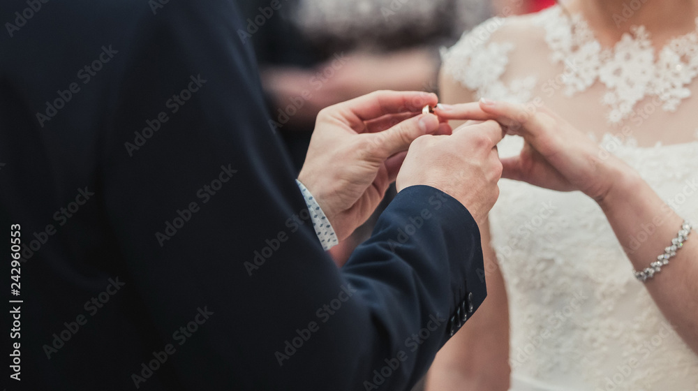 a man wearing a wedding ring for his bride during the ceremony and the sacrament of the wedding. A pair of pairs