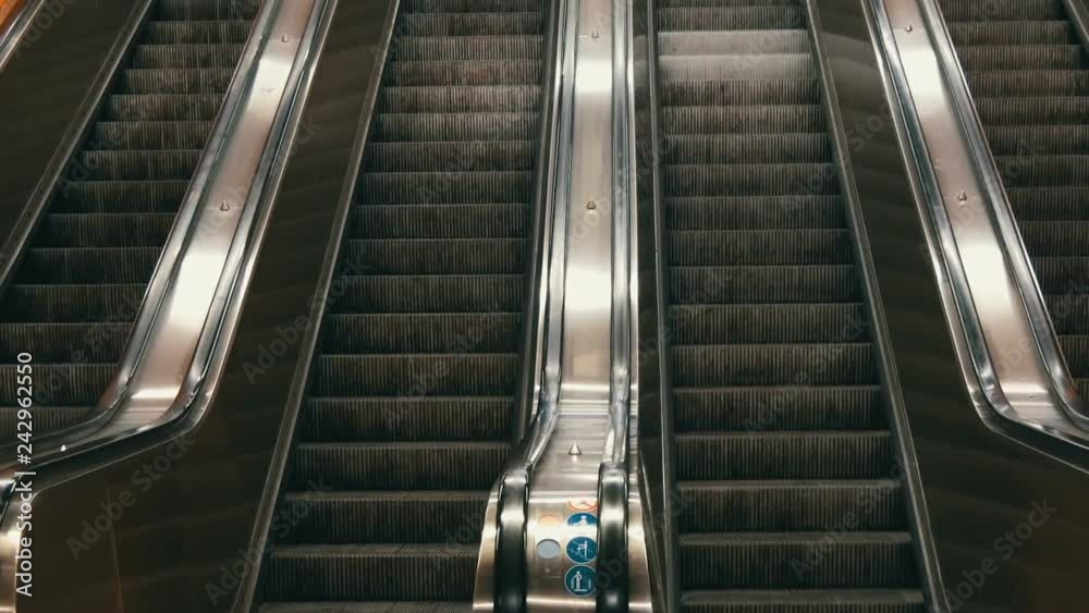 Large modern escalator in subway. Deserted escalator without people on four lanes that move up and down Large modern escalator in subway. Deserted escalator without people on four lanes that move up and down