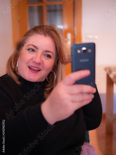 Mature woman takes a selfie portrait with a smile in his face