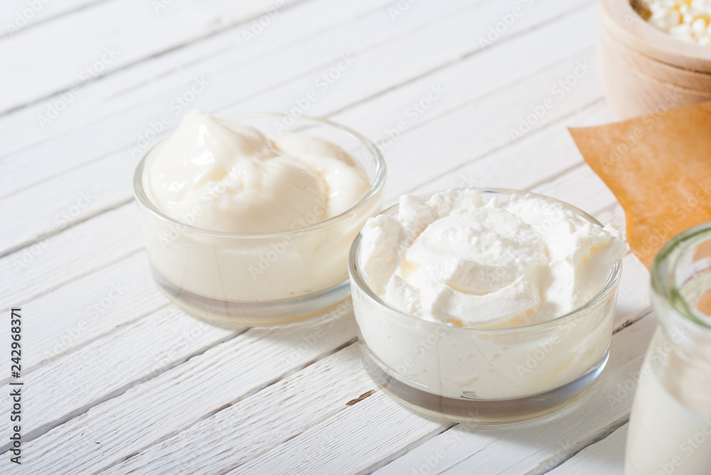 yogurt and creme fraiche on white wooden table background yogurt and creme fraiche on white wooden table background