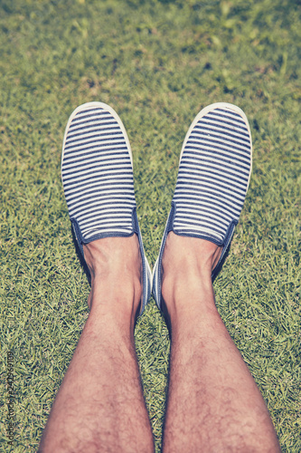 Man in striped shoes on the grass.