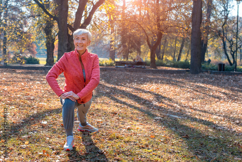 Portrait of smiling senior woman exercise outside in park