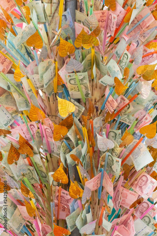 Fototapeta premium Pile of randomly scattered of thai bhat banknotes on bamboo for donate some money to charity stick