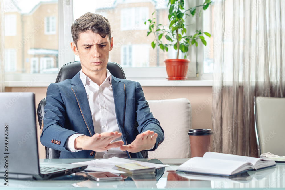Official businessman sitting at workplace in office refuses bribes. Concept of corruption and bribery Official businessman sitting at workplace in office refuses bribes. Concept of corruption and bribery