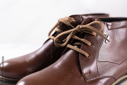 Men's classic brown leather shoes on white background. Close up
