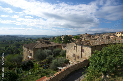 Siena / Italy - September 25 / 2015 : View of San Gimignano with houses in the forest