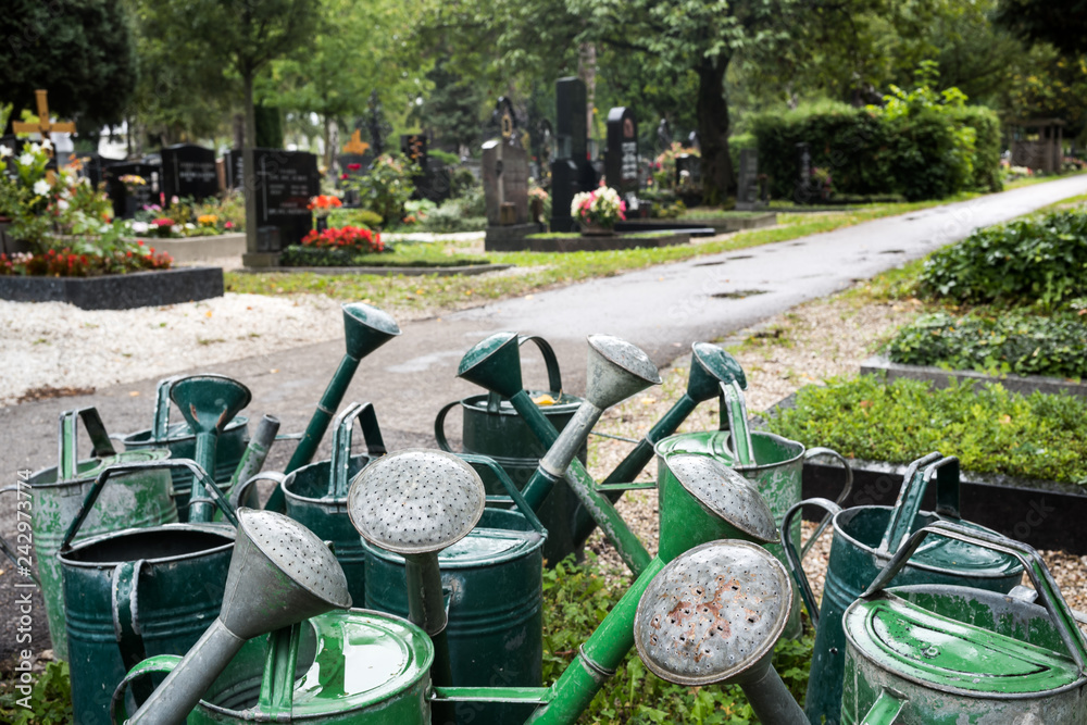 Fototapeta premium Gießkannen auf einem Friedhof