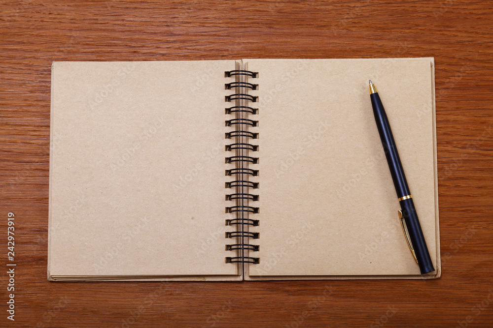 Notepad or notebook with pencil on brown wood table background.using wallpaper for education, business photo Notepad or notebook with pencil on brown wood table background.using wallpaper for education, business photo