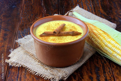 Curau, cream of corn sweet and dessert typical of the Brazilian cuisine, with cinnamon placed in ceramic bowl on wooden table. Copy space photo