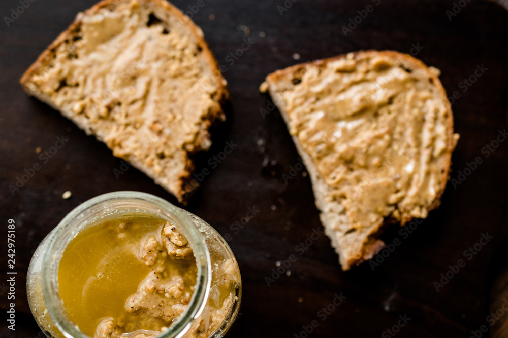 Jar of Creamy Peanut Butter with Bread on Wooden Surface. Jar of Creamy Peanut Butter with Bread on Wooden Surface.