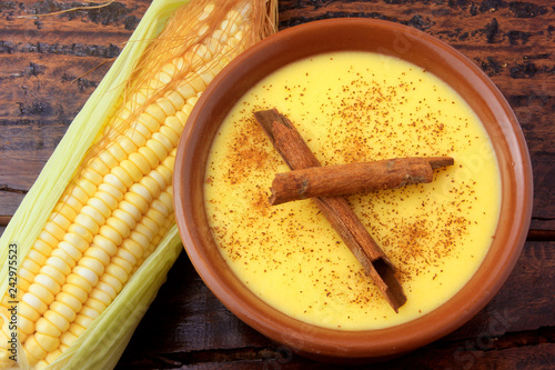 Curau, cream of corn sweet and dessert typical of the Brazilian cuisine, with cinnamon placed in ceramic bowl on wooden table. Top view photo