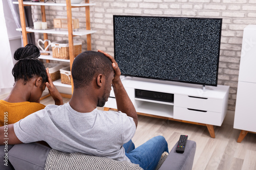 Couple Sitting Near Television With No Signal