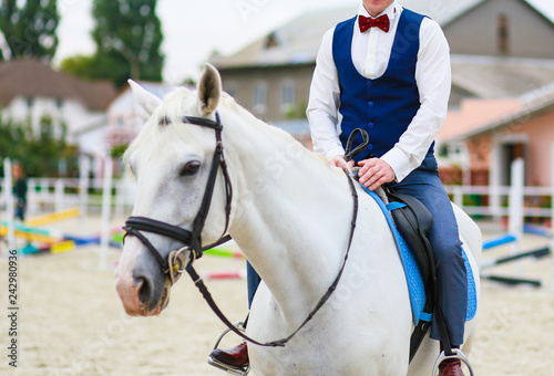 Stylish man in a suit on a white horse. Prince on a white horse