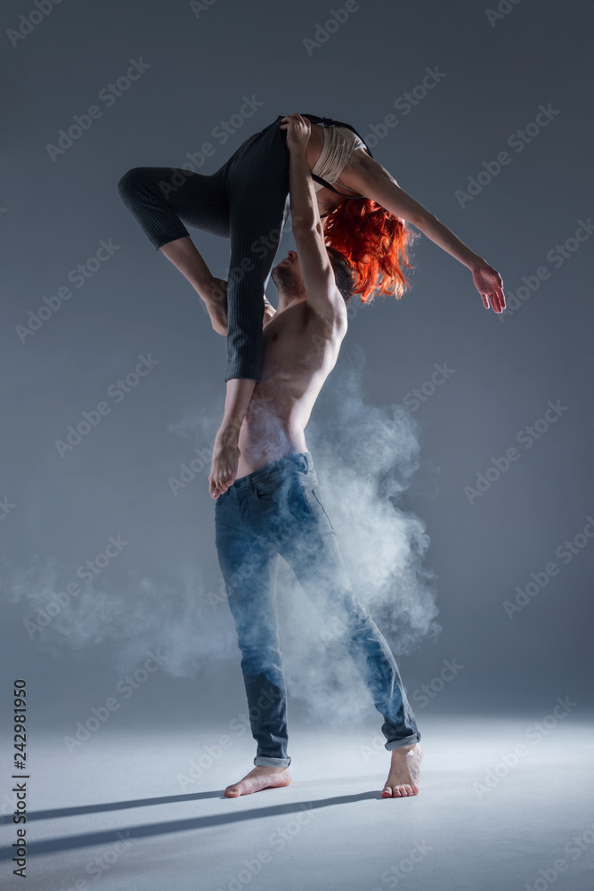 Hip Hop Dancer Nude Girl - Couple in love dancers making dance element in smoke fume on isolated grey  background scene. Redhead