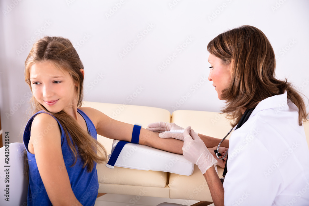 Doctor Taking Blood Sample Of An Afraid Child Patient Doctor Taking Blood Sample Of An Afraid Child Patient