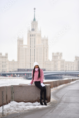 Asian girl on the river embankment in the city in winter 