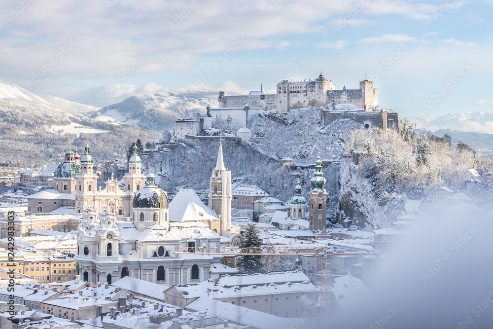Obraz premium Panorama Salzburga zimą: zaśnieżone historyczne centrum, słońce