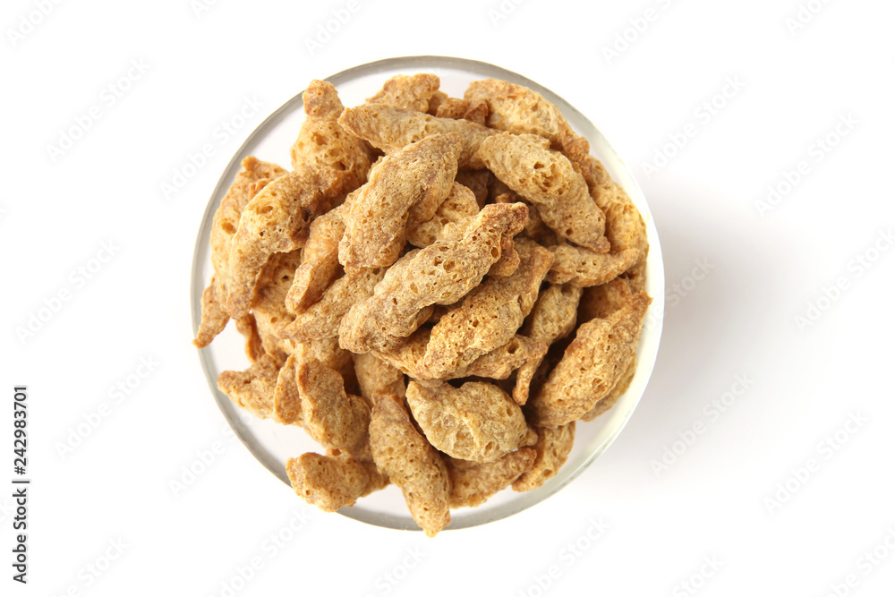 Raw soy chunks in glass bowl isolated on white background. Dry soya pieces meat used in vegetarian and vegan food. top view