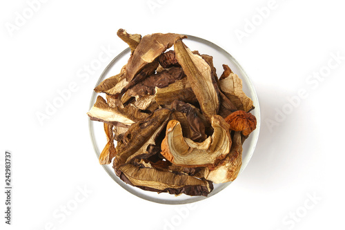Dried mushrooms in glass bowl isolated on white background. Wild edible dried boletus mushrooms. top view