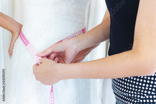 Tailor is measuring bride.She prepare the set for celebrate wedding.happy , dress, Photo concept marry and beautify. 