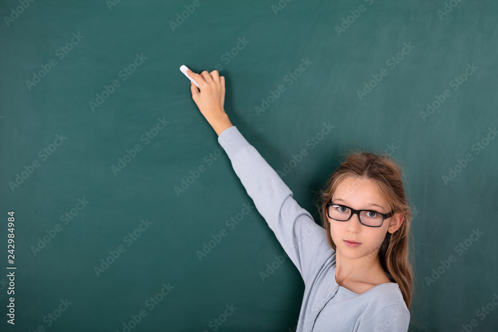 Girl Writing With Chalk On Green Board