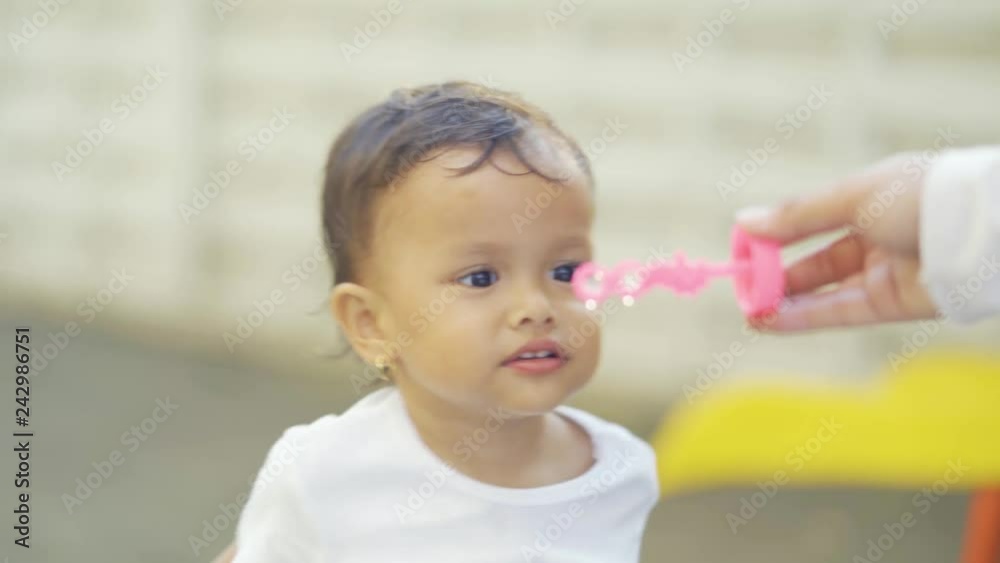 Adorable little girl blowing soap bubbles at the park. Shot outdoors in 4k resolution Adorable little girl blowing soap bubbles at the park. Shot outdoors in 4k resolution