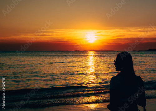 Back view portrait of a lonely woman with sunglasses at the beach sunset.sunlight outdoor