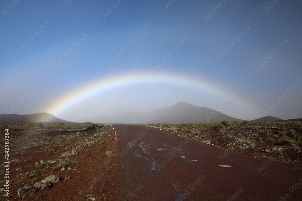 Rainbow stretched over the road in the mountains