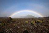 Over a few mountains in the fog stretched a rainbow